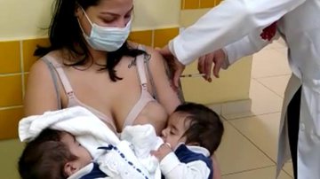 A lactante Giovanna Lizandra dos Santos Deckenbach amamenta filhos gêmeos enquanto toma vacina, no município de Mauá - Foto: divulgação/prefeitura Mauá