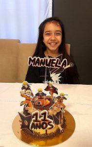 Manuela atrás de um bolo de aniversário