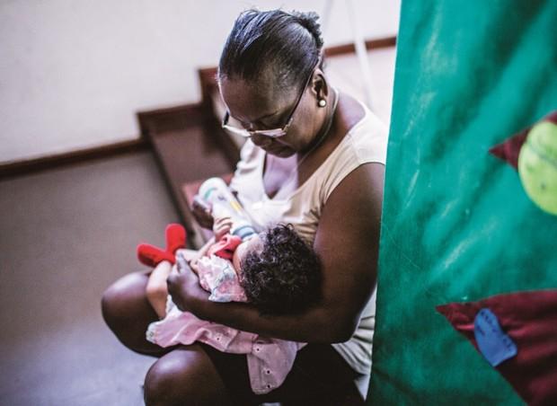 Funcionária alimenta bebê na Unidade de Reinserção Social Ana Carolina, no Rio de Janeiro. No ano passado, o abrigo recebeu 61 bebês e crianças de até 4 anos filhos de usuárias de crack (Foto: Guilherme Zauith/Ed. Globo)