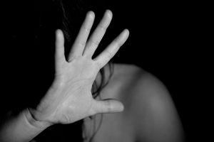 Imagem mostra mulher ameaçada representando violência doméstica