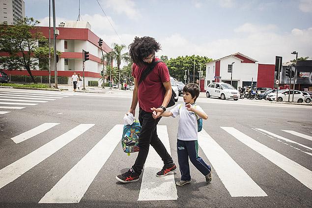 Diagnosticado com autismo, Luis Felipe, 7, é acompanhado por Marcelo Fonseca até a escola