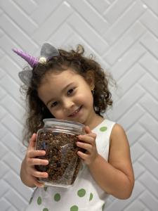 Menina segurando um pote de granola