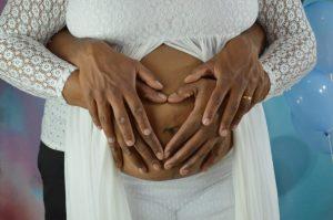 Foto de grávida e homem com as mãos na barriga