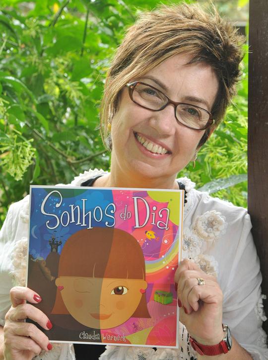 A jornalista e escritora Claudia Werneck com  um de seus livros (Foto: Divulgação)