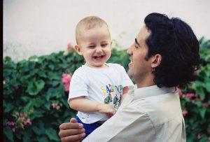 Roberto sorrindo com seu filho no colo