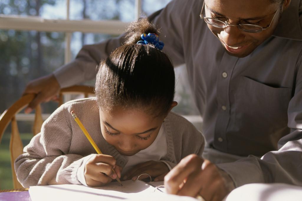 Close-up of a father helping his daughter with her homework