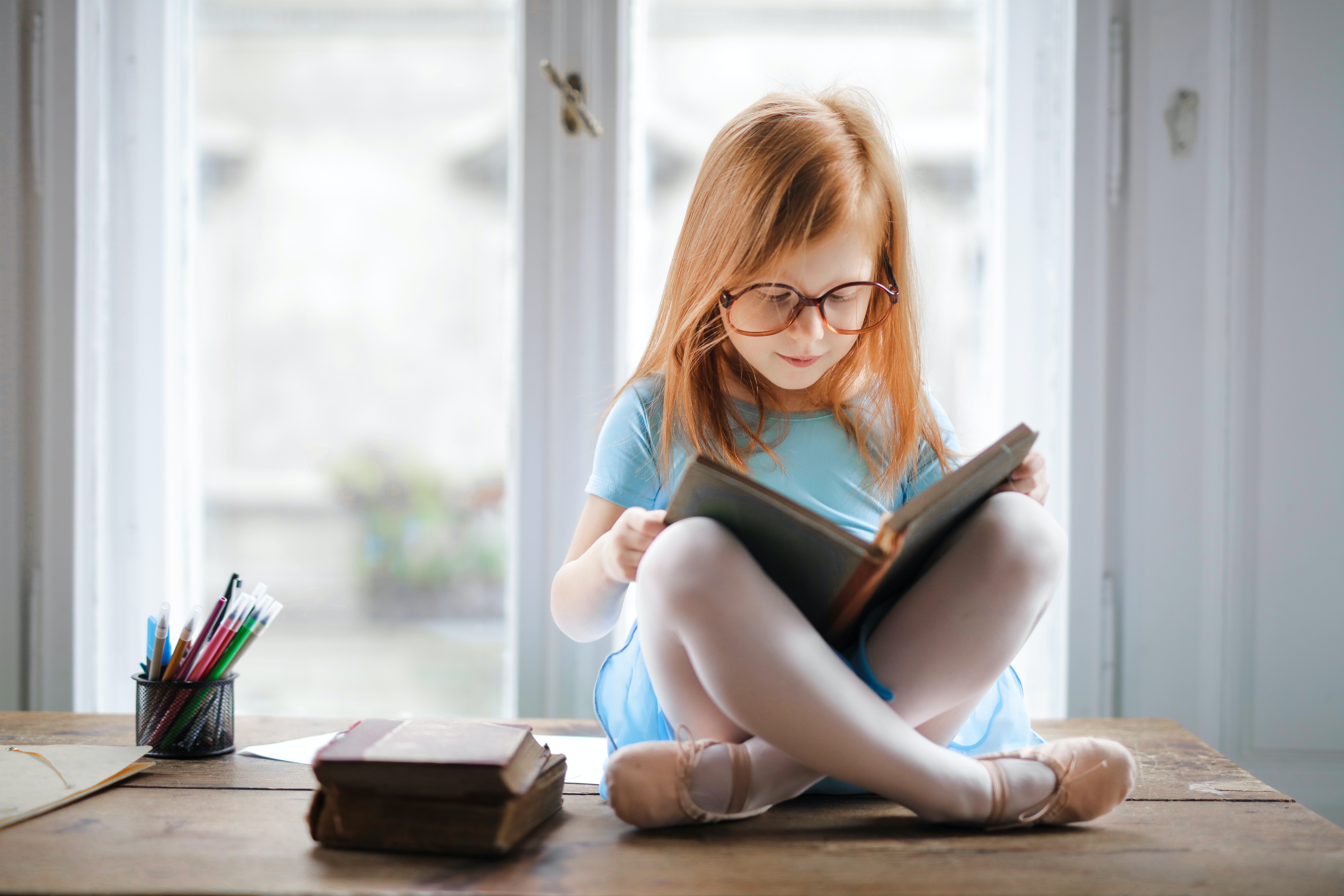 criança ruiva lendo livro