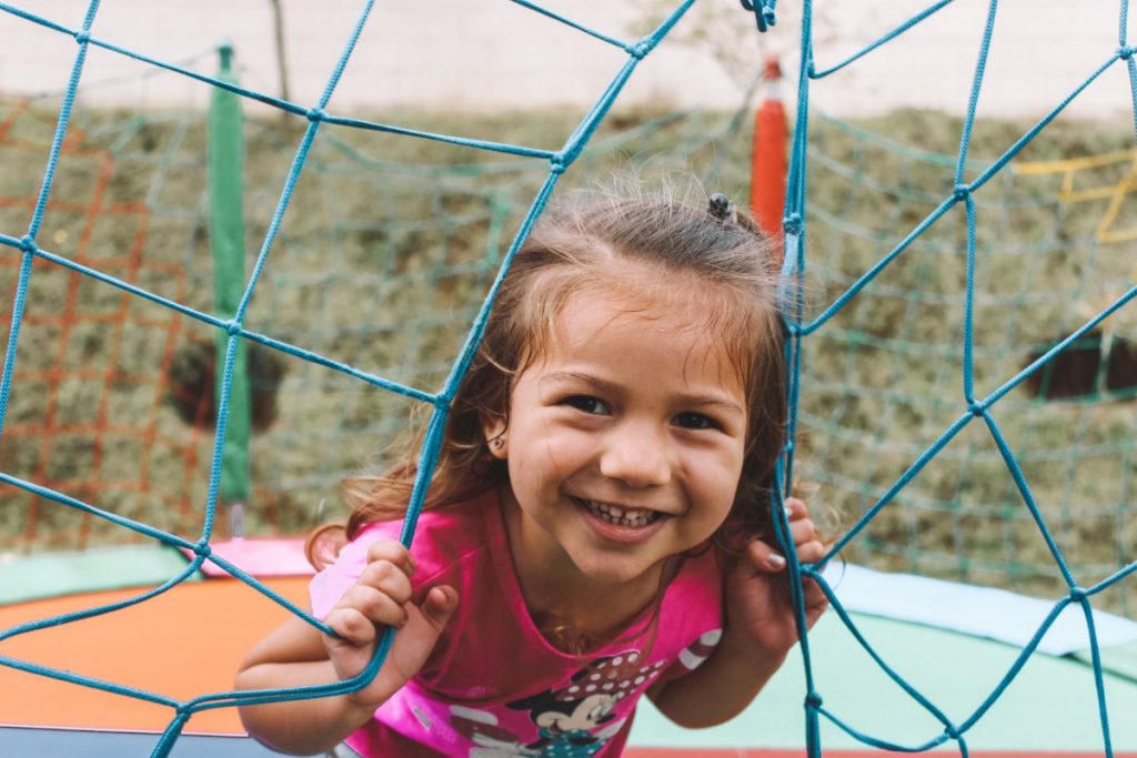 Menina em cama elástica sorrindo