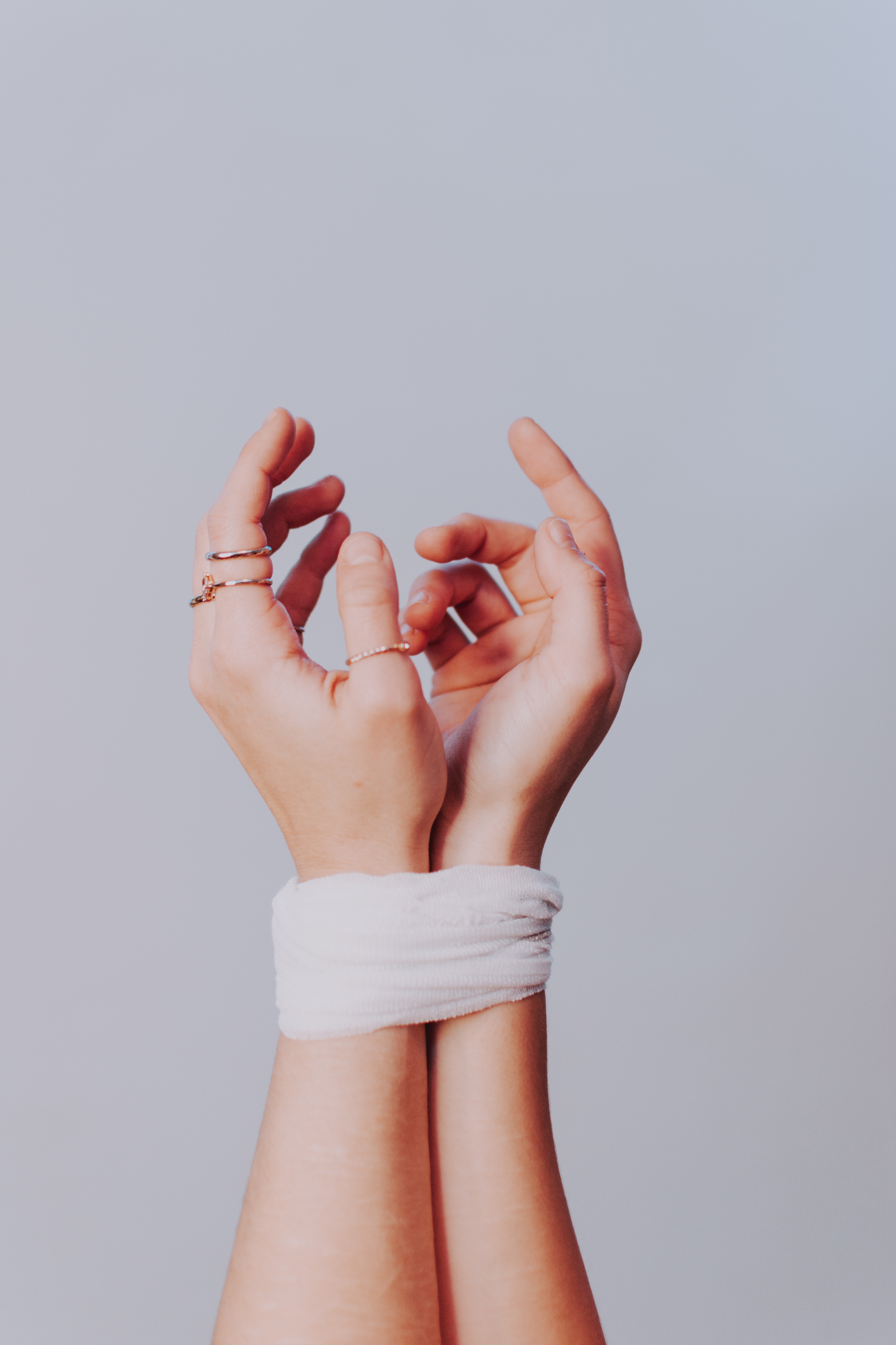 Foto mostra mãos de mulher amarradas por um tecido branco