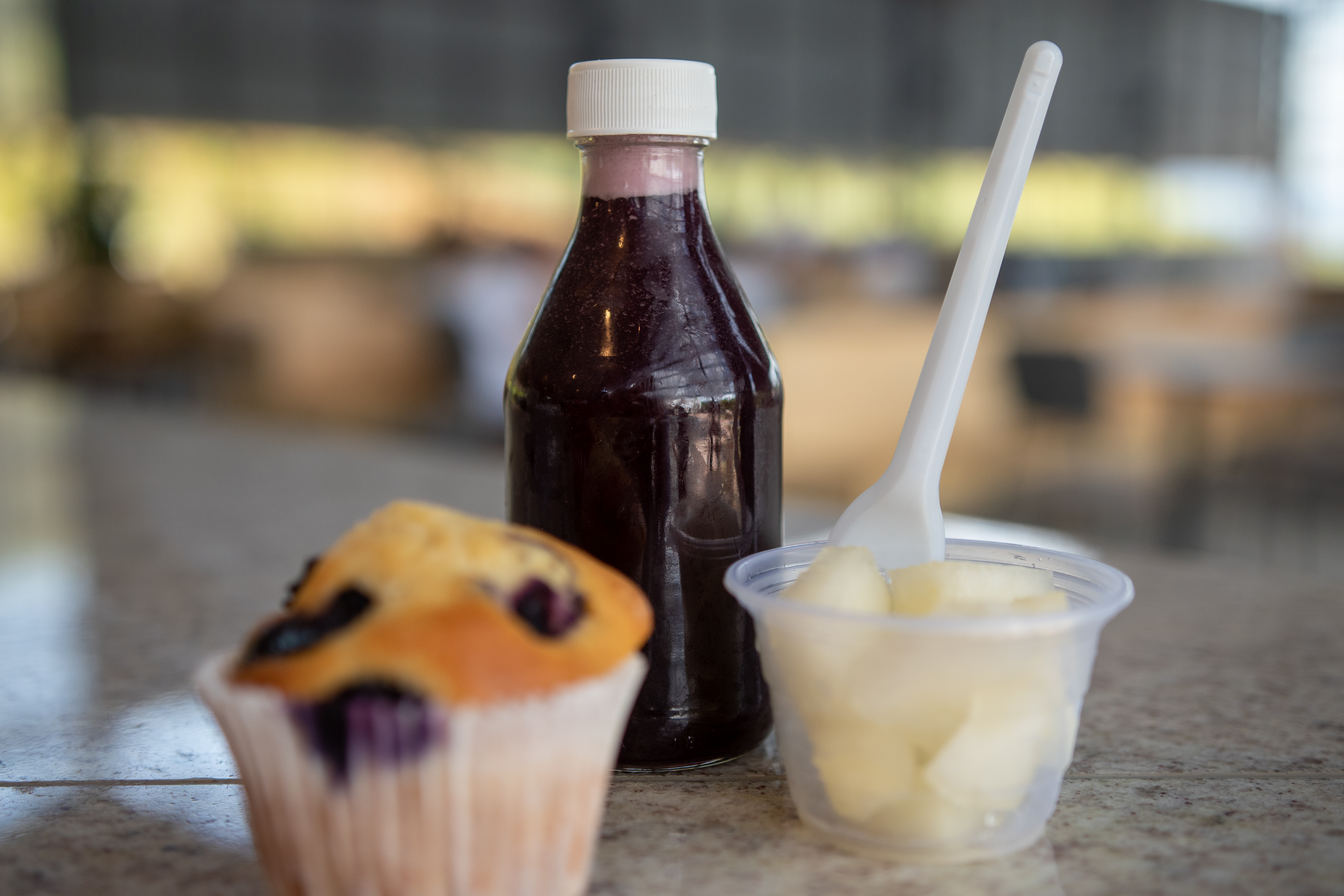 Imagem com um muffin, um suco de uva e melão cortado em cubos