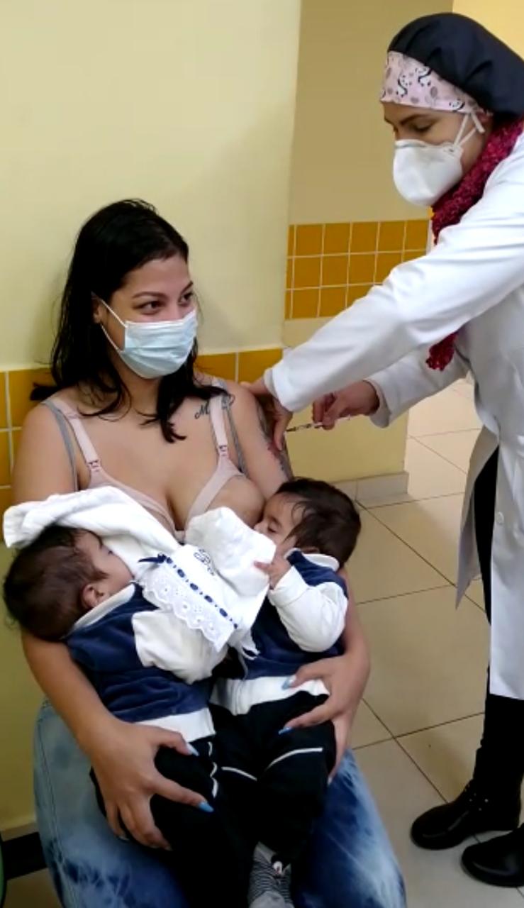 Giovanna sendo vacinada enquanto amamentava os filhos gêmeos