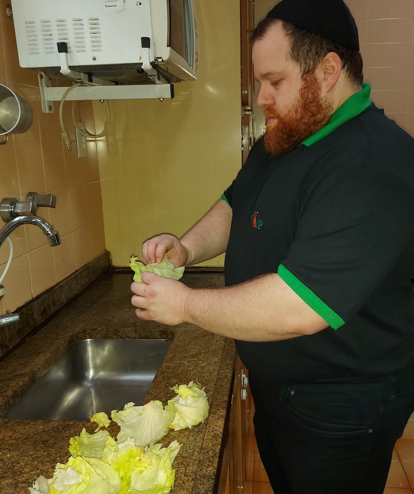 Raphael Orlean fazendo a lavagem dos alimentos